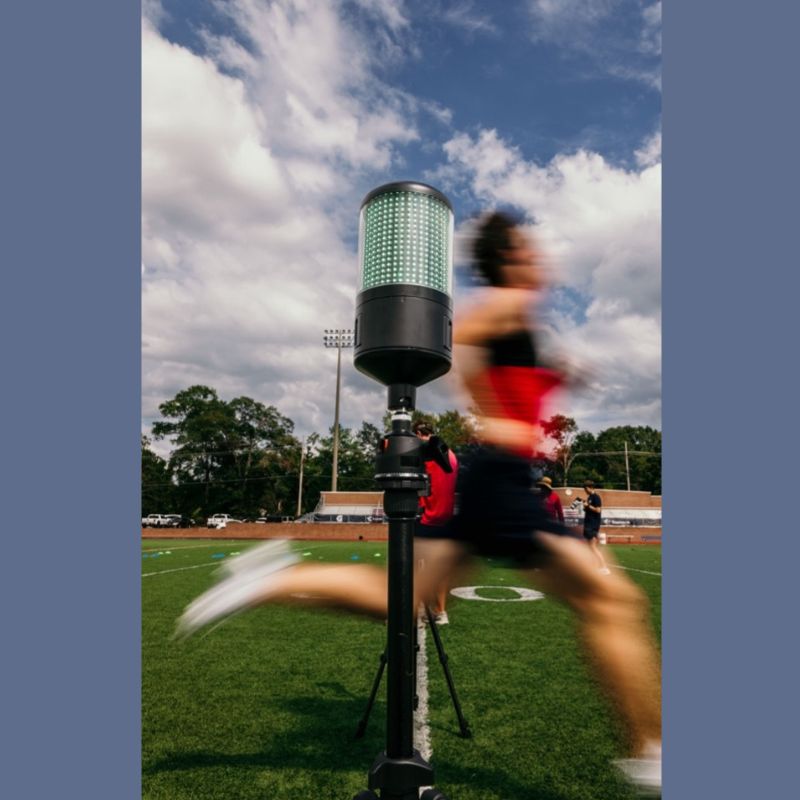 Athlete sprints through timing gate as part of speed training program.