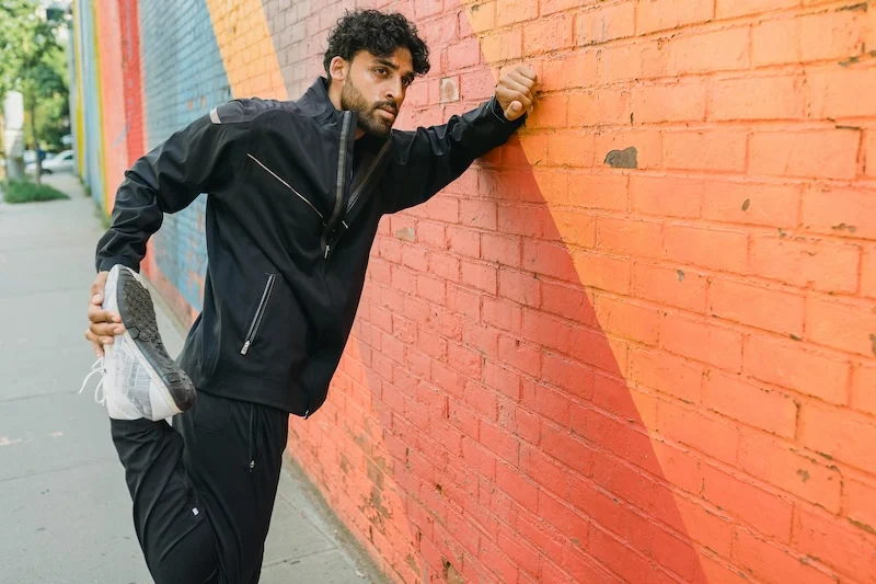 Someone doing the quadriceps stretch against a wall.