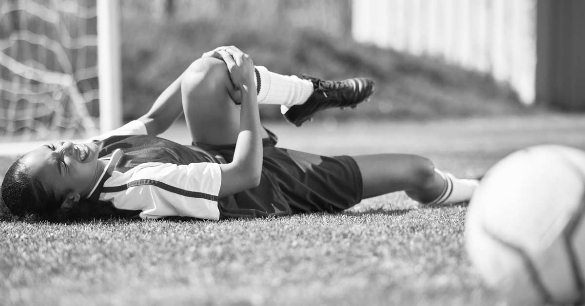 ACL Injury|A person is sitting in the backseat of a car with one leg in a knee brace. The leg is elevated and wrapped in bandages