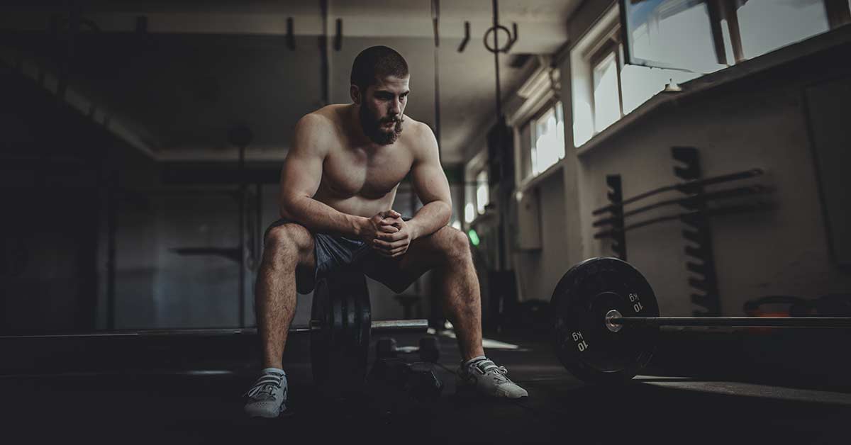 Athlete in Weight Room|Grip Strength Sequence|Eye Charts|A person in a gym is undergoing a training exercise using a pulley system. Theyre holding a rope attached to the frame