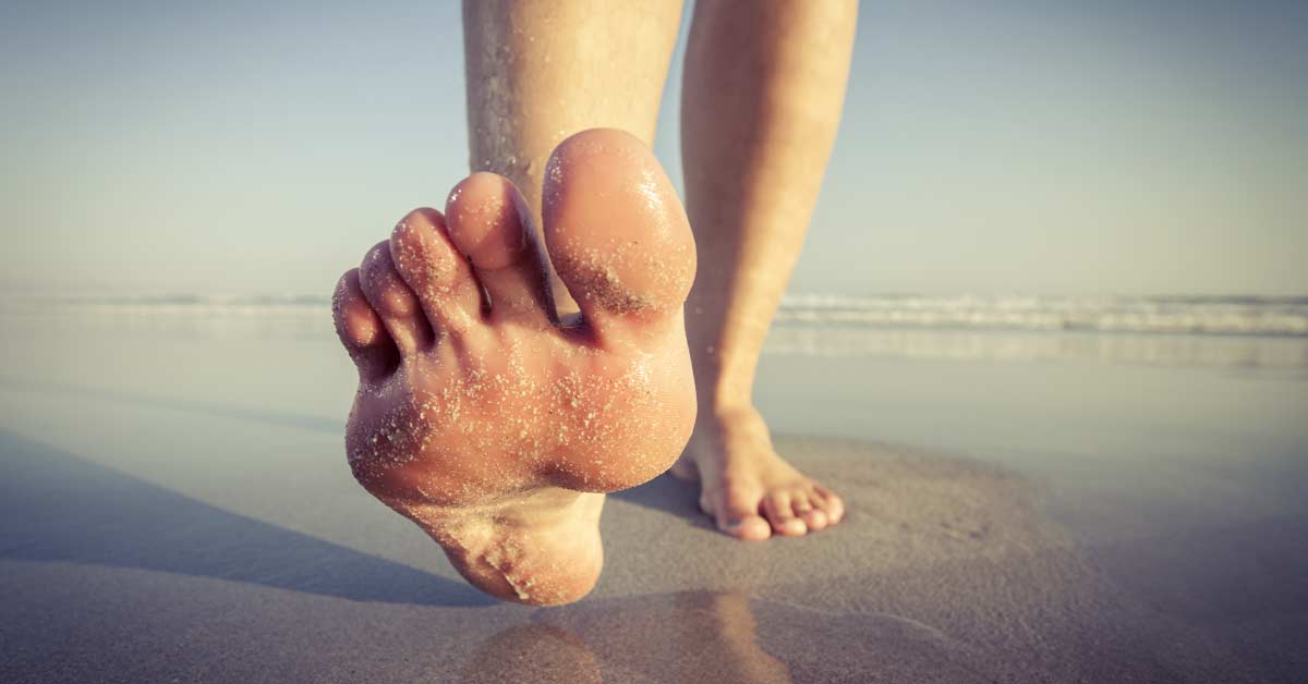 Barefoot Running|Close-up of a persons bare feet walking on a sandy beach