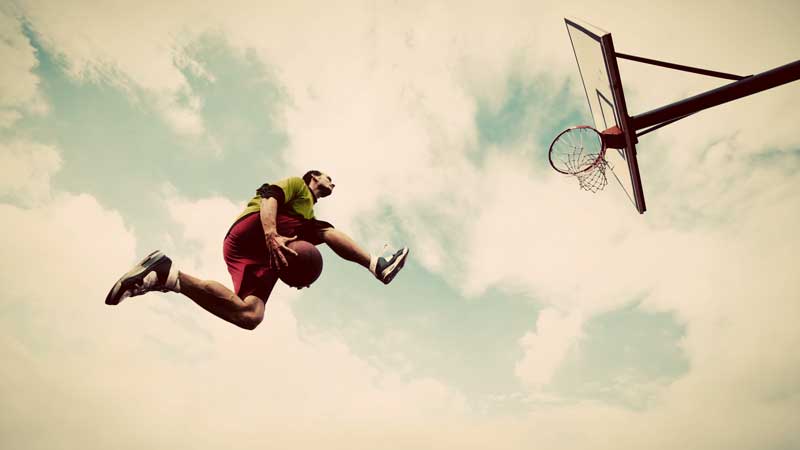 Basketball Dunk|A person in shorts and a t-shirt stands on a black mat outdoors