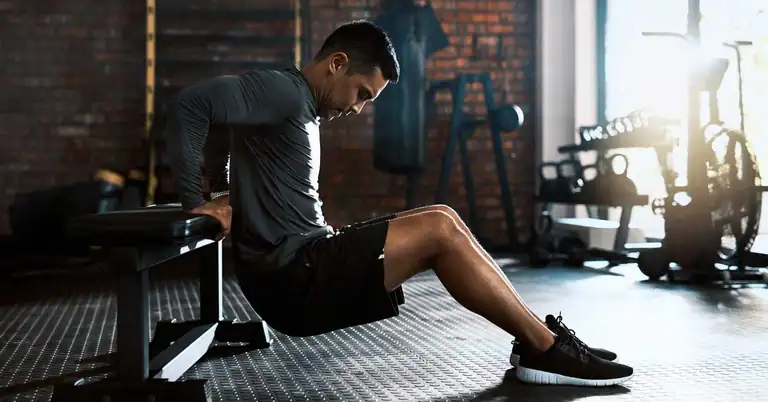 Male athlete performing a chair dip|Tricpes