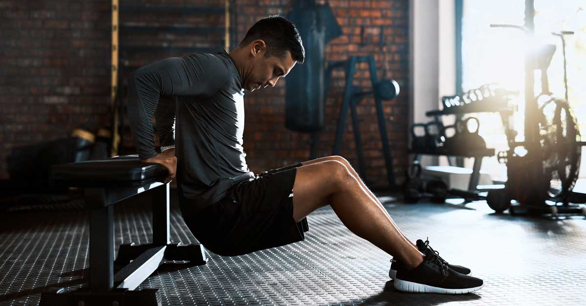 Male athlete performing a chair dip|Tricpes