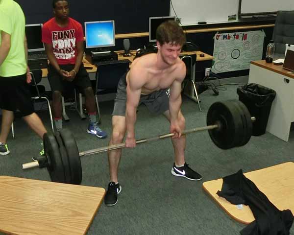 Students perform deadlift in classroom