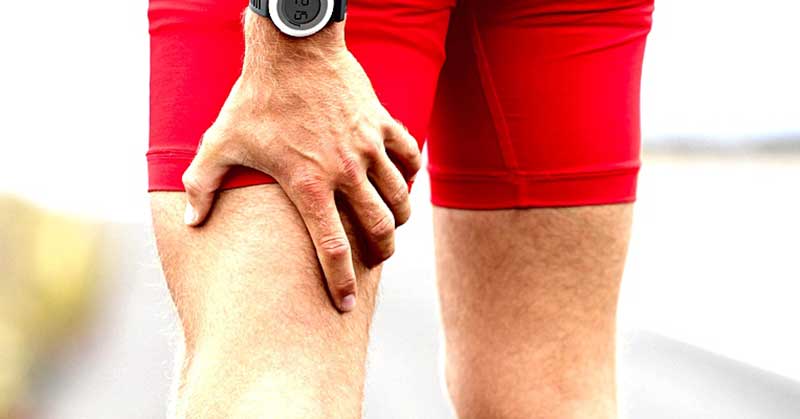 A person in red shorts holds the back of their right leg