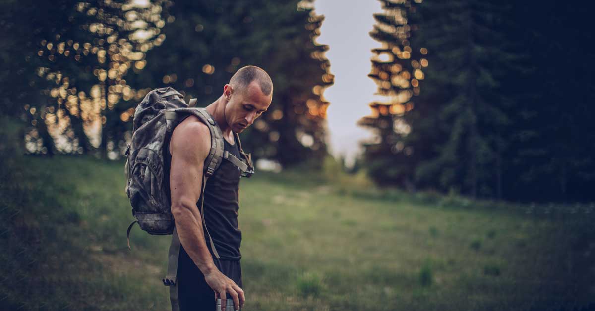 Tactical Athlete on Hike|A person aims a Nerf gun at a paper target taped to a box. The target shows a stick figure labeled Bad Guy with circles for the head and torso
