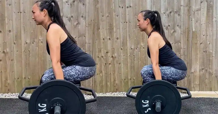 Lumbar Spine Posture Lifting|Kettlebell Posture|Tape application|Spinal Flexion|Snatch Grip Deadlift|Trab Bar Deadlift|A woman in workout attire performs a squat on wooden blocks while holding a white rod behind her shoulders. She stands on a paved surface with a wooden fence in the background.