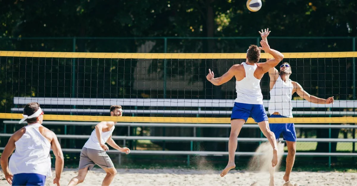 Two opposing volleyball players facing each other at the net