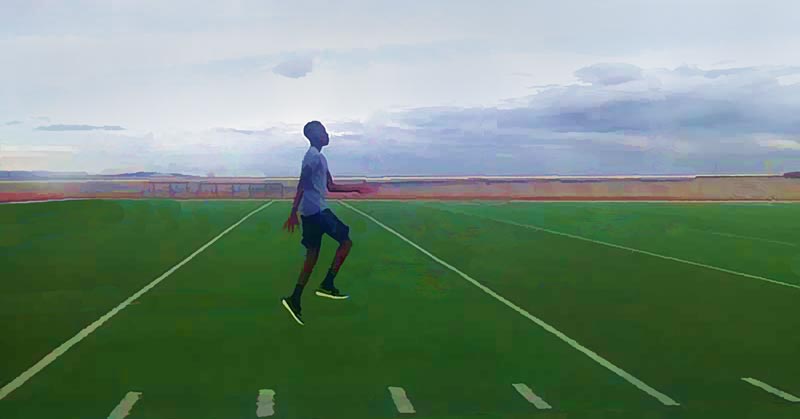 Jumping Drills|A person is mid-stride while running on a football field