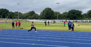 Mortimer-Hobbs|A coach wearing sunglasses and a cap is talking to a seated athlete on the sidelines of a running track. Other people are exercising on the track in the background.|A black and white image of a person sprinting on a track