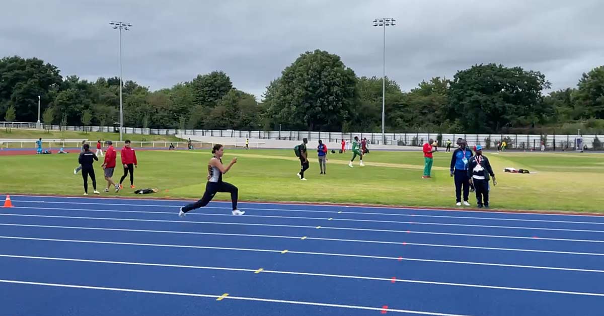 Mortimer-Hobbs|A coach wearing sunglasses and a cap is talking to a seated athlete on the sidelines of a running track. Other people are exercising on the track in the background.|A black and white image of a person sprinting on a track