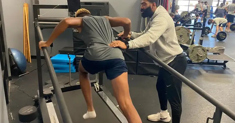 A person exercises on a treadmill with inclined rails