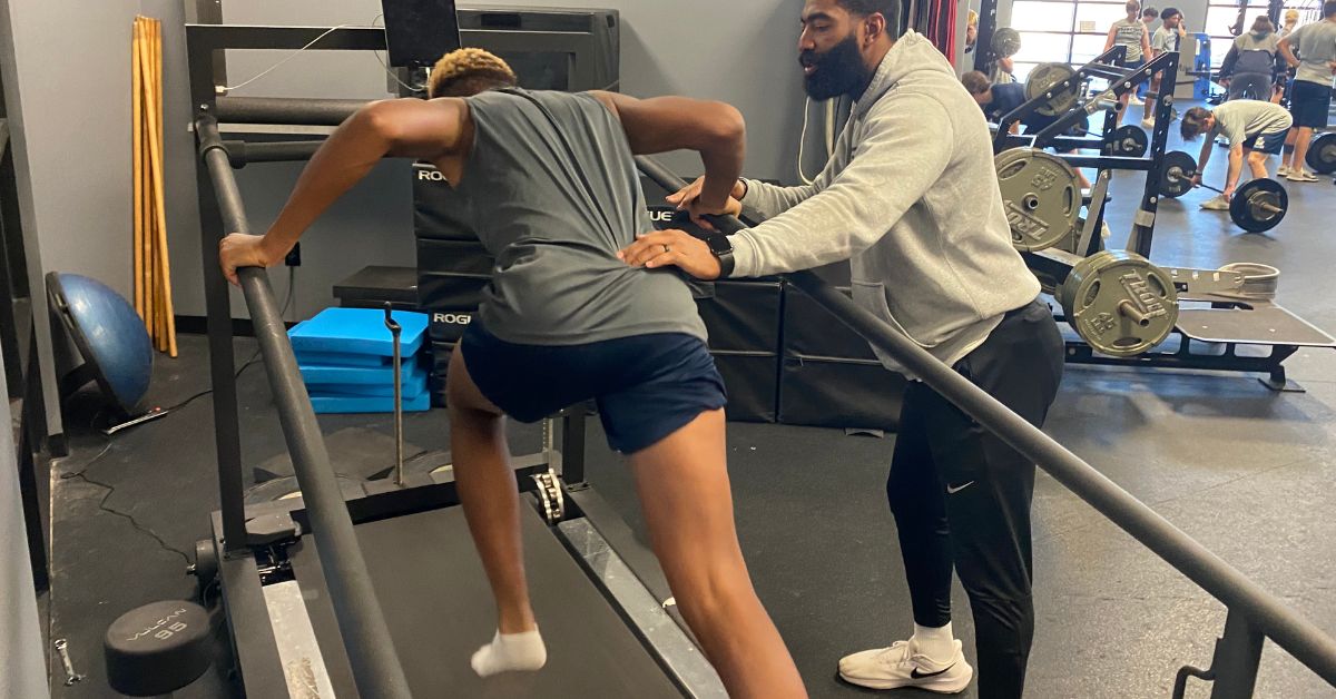 A person exercises on a treadmill with inclined rails