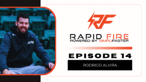 A bearded man in a tracksuit smiles while sitting in green stadium seats. Next to him is the Rapid Fire Powered by SimpliFaster logo