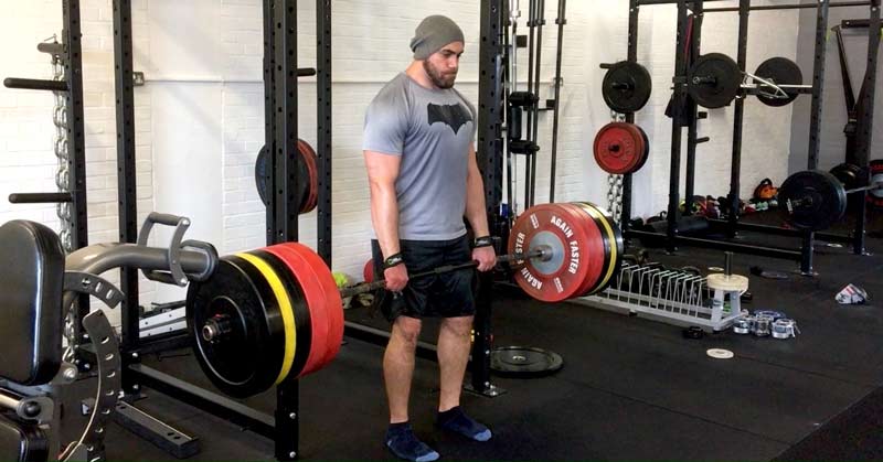 Romanian Deadlift|Peak Week|RDL Periodation|A man in a gray shirt and beanie stands in a gym