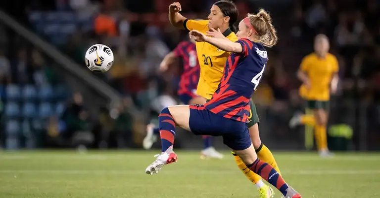 Sauerbrunn Multisport|Wambach Header|Cards Autographs|Pitcher Center Back|Goal Keeper running the bases|Multisport Twins|Top: Girls playing soccer on a field. Middle: A girl in maroon and gold softball gear batting at a softball game. Bottom: A girl in a white and maroon jersey preparing to catch a football during a game.