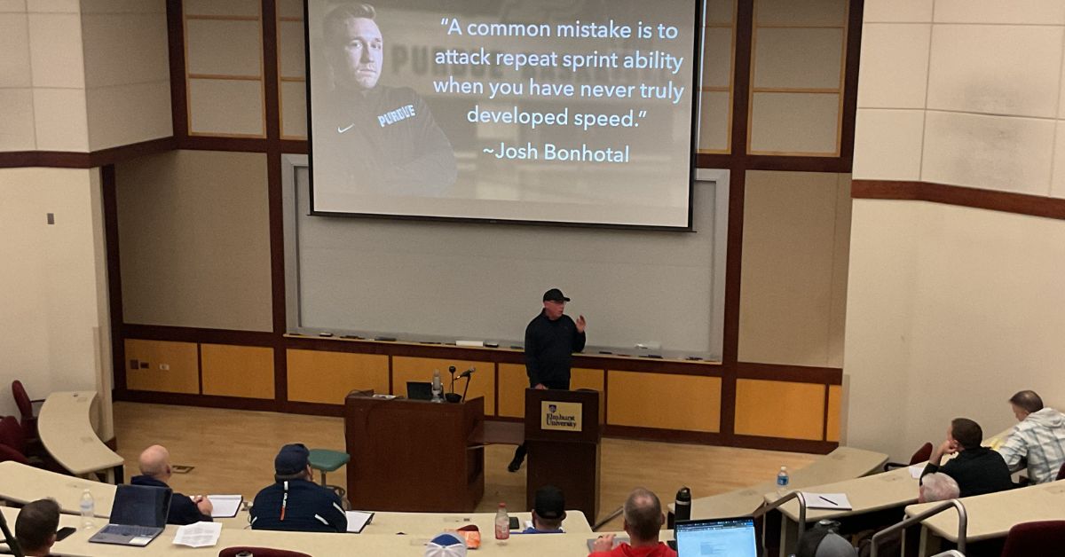 TFC Tony Holler Speed|Tradition and Disruption|Brad Dixon Presentation|A man presents slides to a seated audience in a classroom. The top slide is titled Tier Functional Movement Patterns