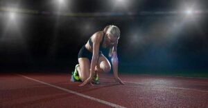 Track and Field Block Start|A track athlete in a blue and orange uniform holds a baton