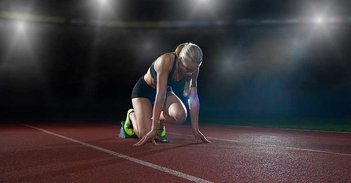 Track and Field Block Start|A track athlete in a blue and orange uniform holds a baton
