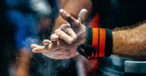 Weightlifter chalks his hands|Strength Coach Books