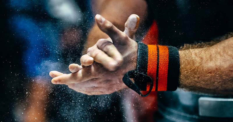 Weightlifter chalks his hands|Strength Coach Books