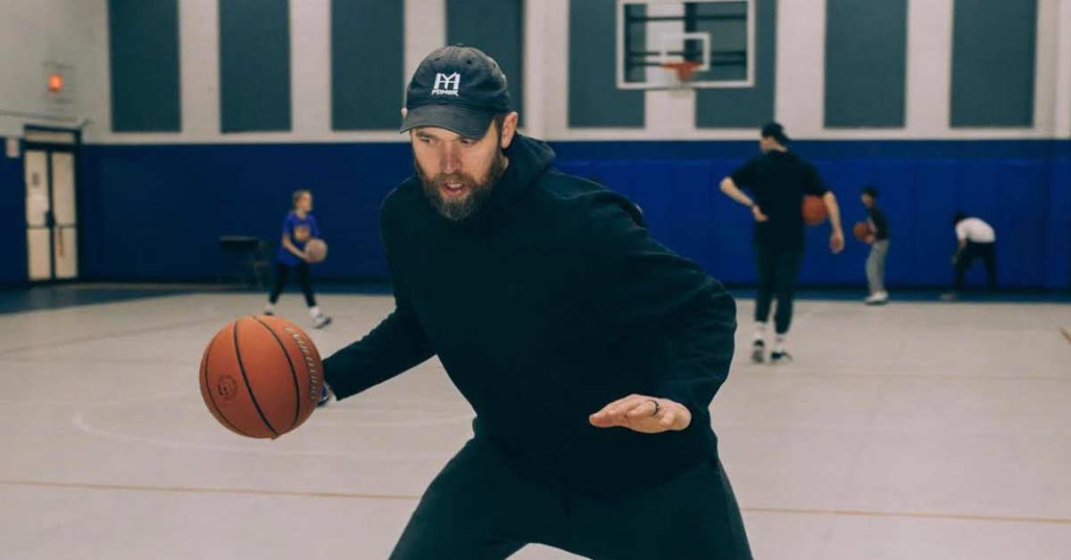 Whyte Hoops|A man in a tie-dye shirt with the words Good Drill dribbles a basketball on an indoor court. He appears focused
