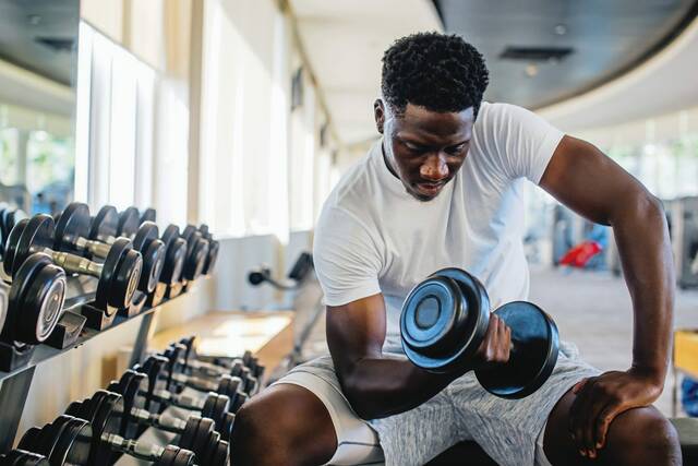 A person lifting weights in a gym

Description automatically generated