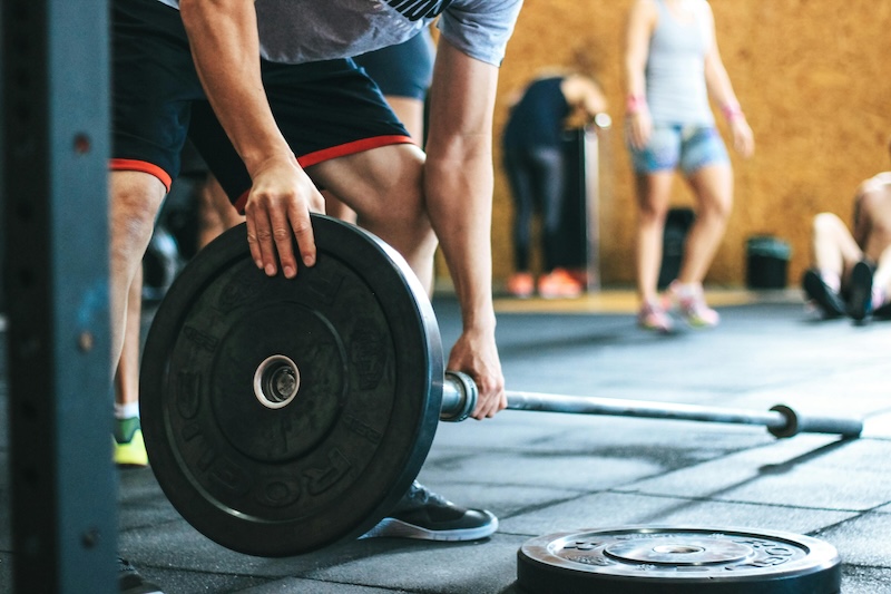 An athlete loading weights onto a bar.