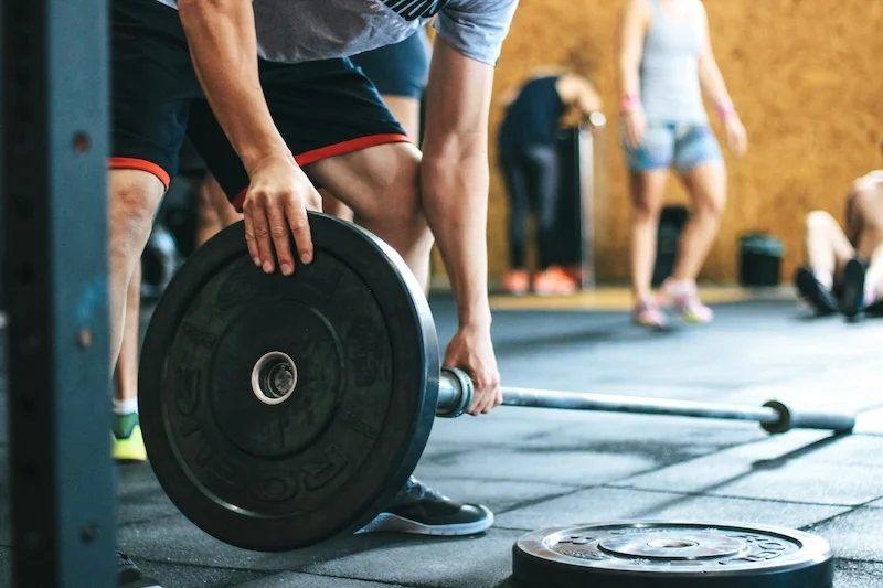 An athlete loading weights onto a bar.