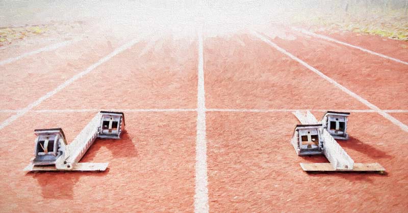 Blocks for Track and Field|Block Start Front View|Four athletes are in starting blocks on an indoor track