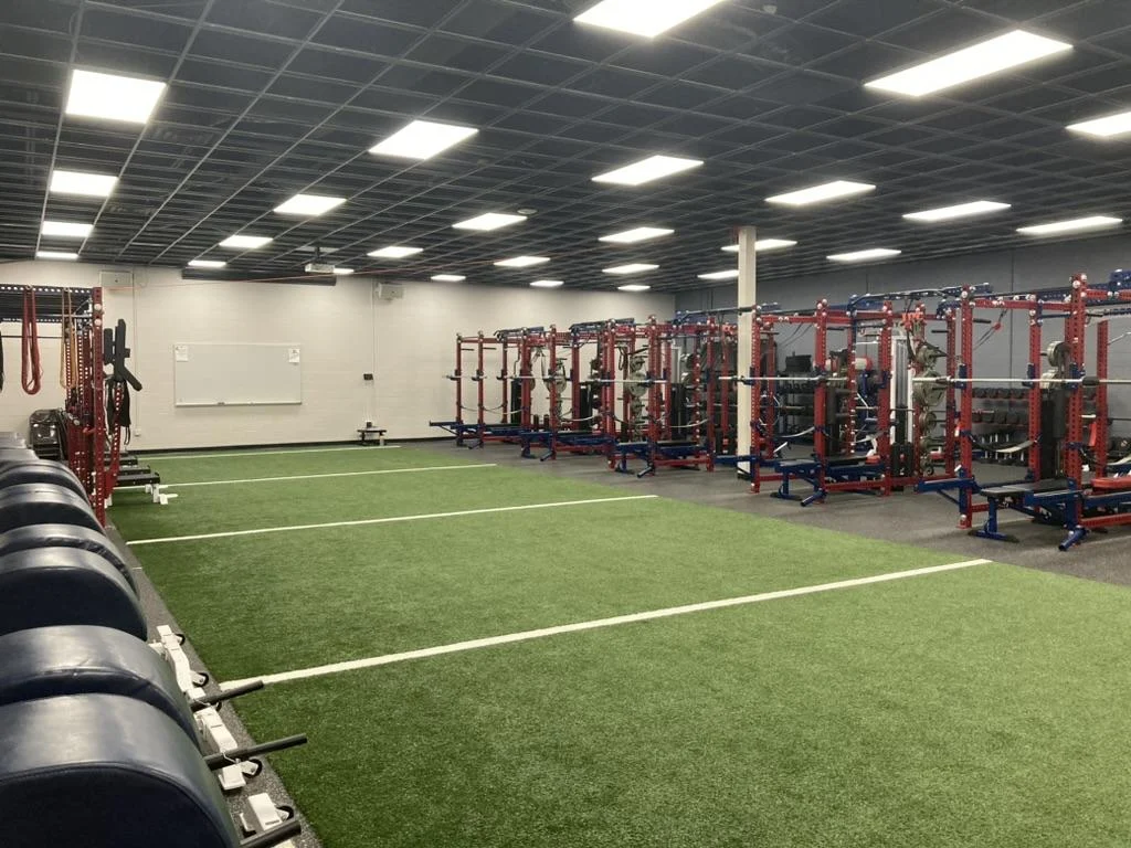 A gym with a green field and a white board

AI-generated content may be incorrect.