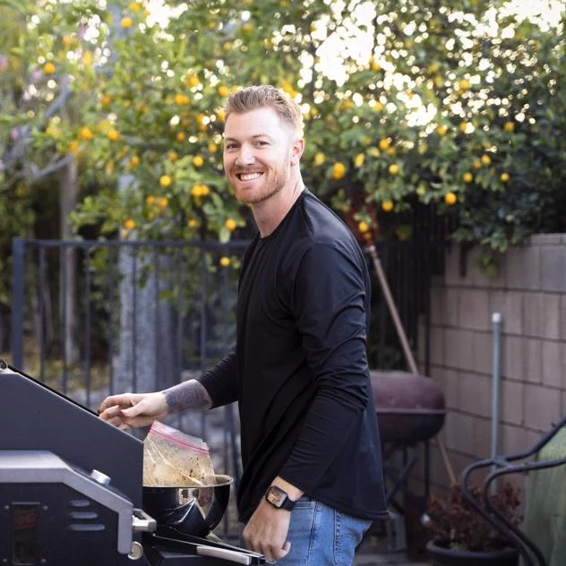 A person cooking food on a grill Description automatically generated