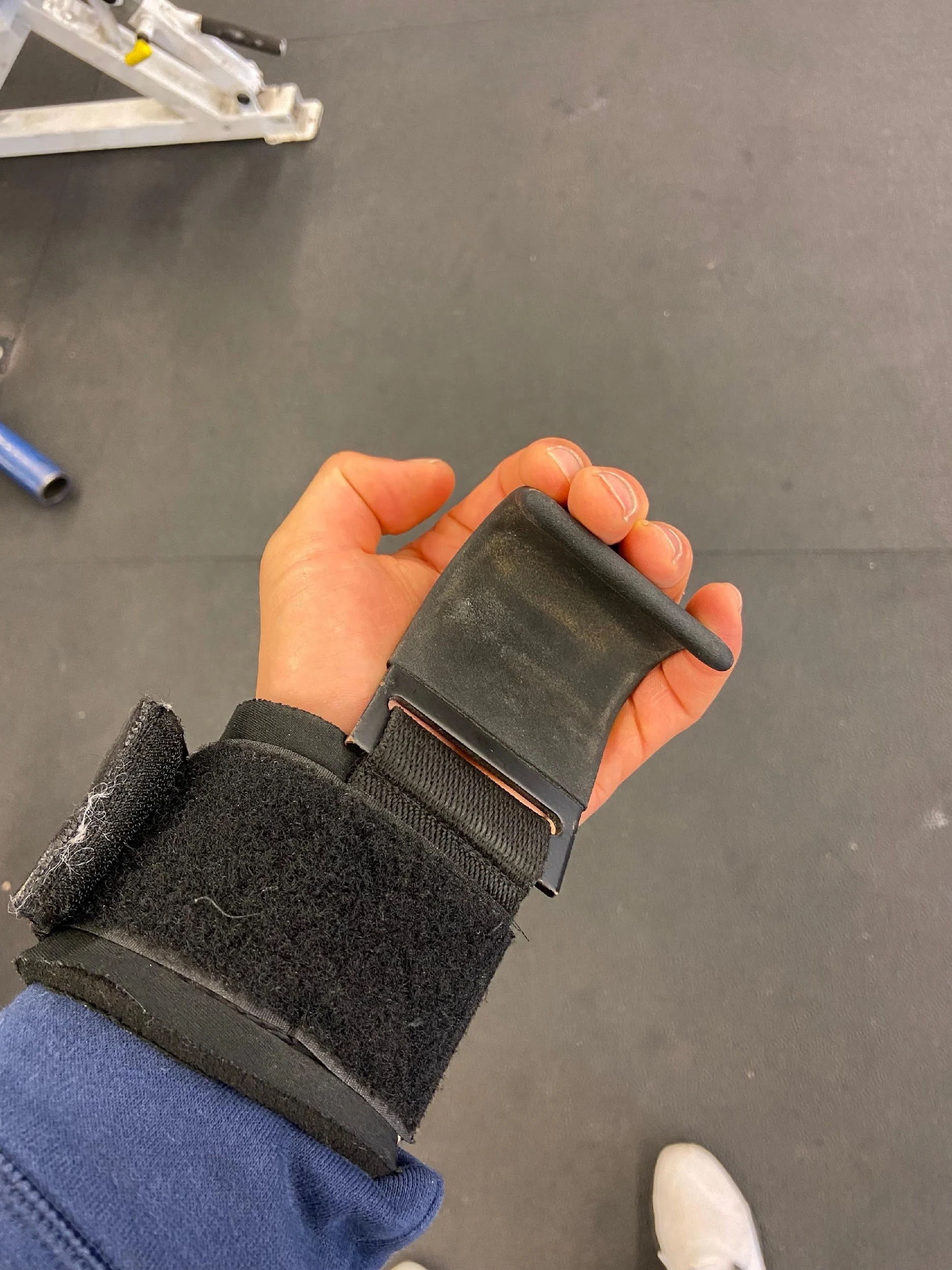 A hand holding a black wrist strap
Description automatically generated