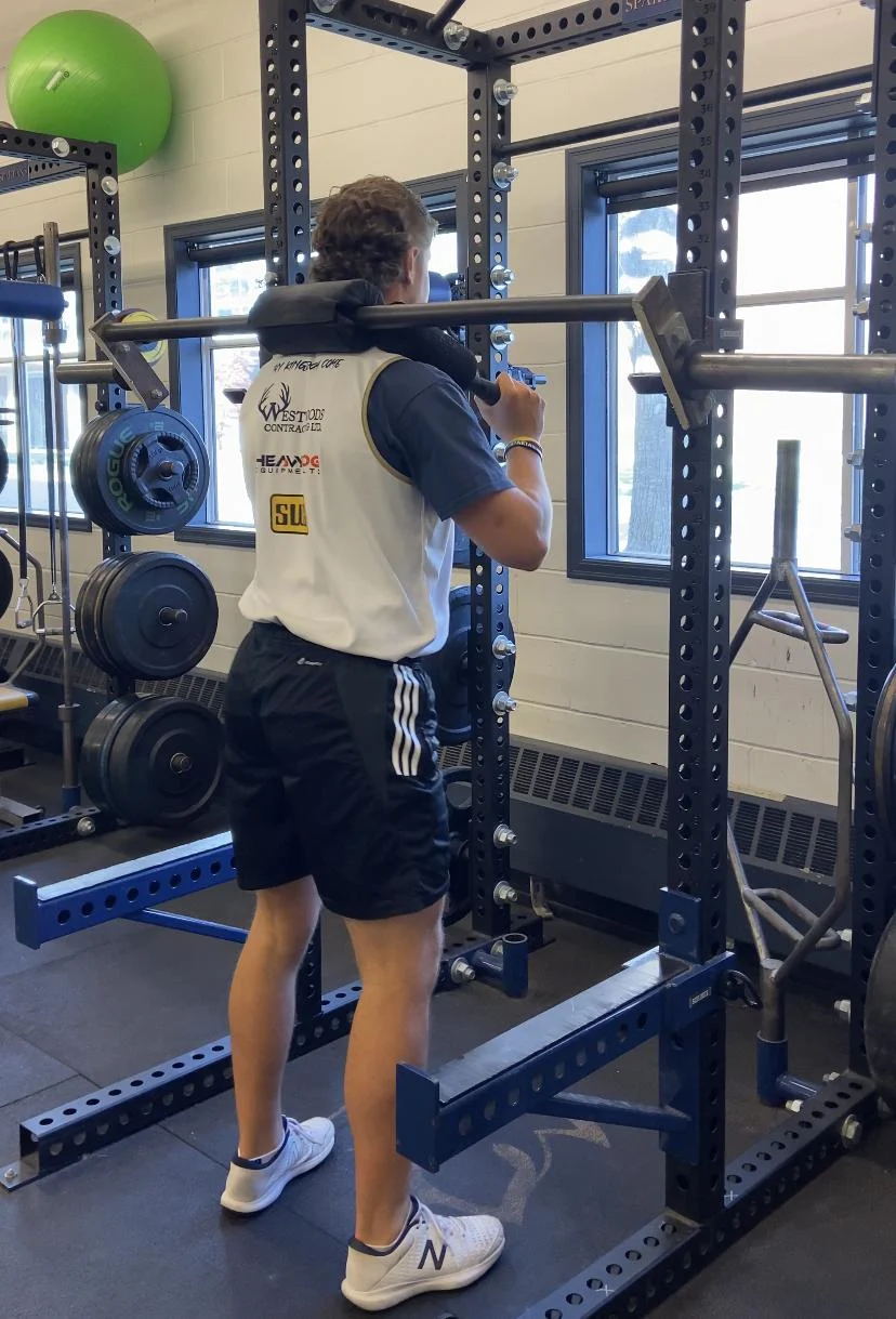 A person lifting weights in a gym
Description automatically generated