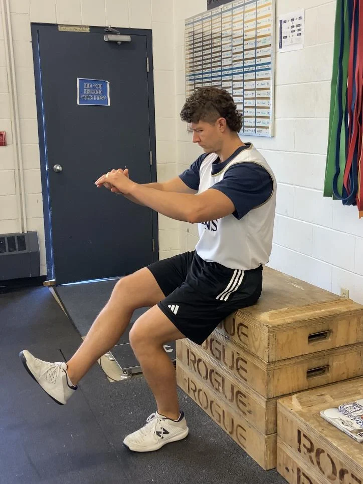 A person sitting on a box
Description automatically generated
